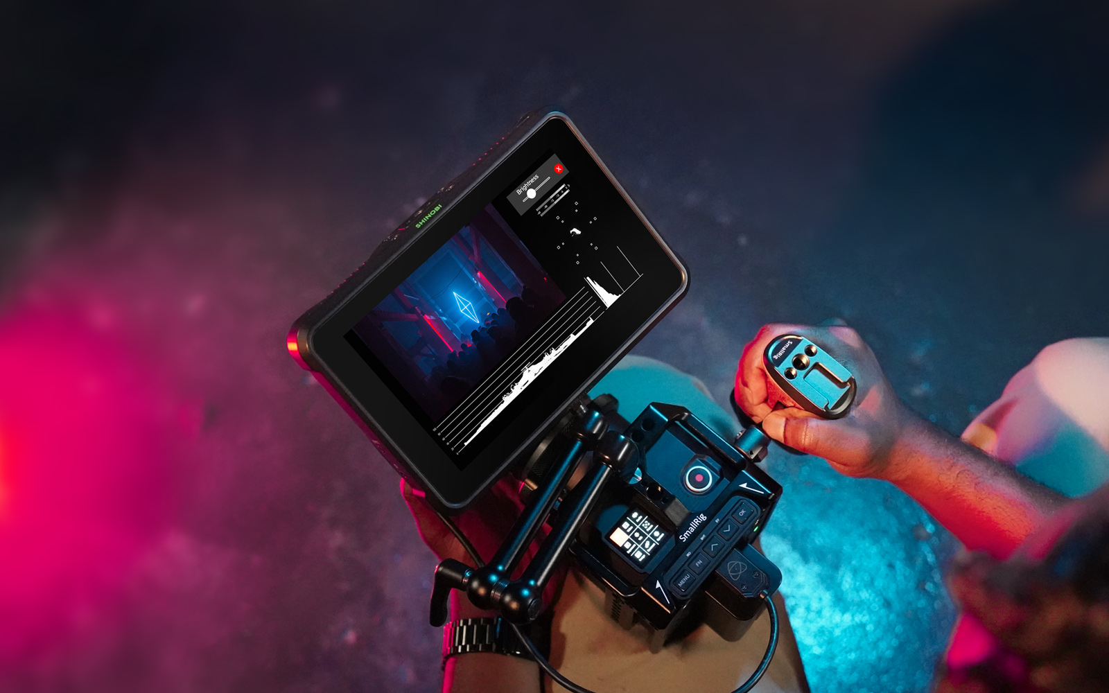 High angle Atomos Shinobi 7 promotional image showing the monitor mounted on top of a camera using a cine arm.