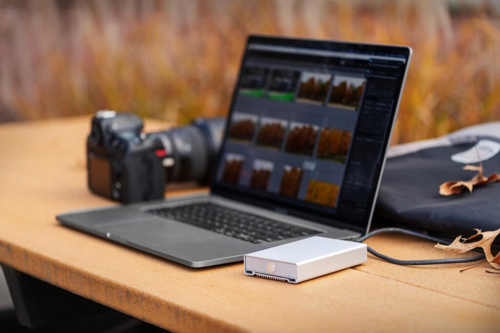 An image of an OWC Mercury Elite Pro mini connected to a laptop out in the field.