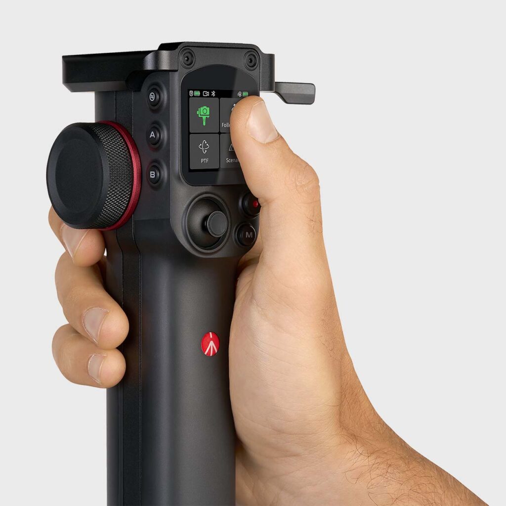 A man's hand uses the touch screen on the Manfrotto MVG300XM Modular 3-Axis Gimbal's removable handle.