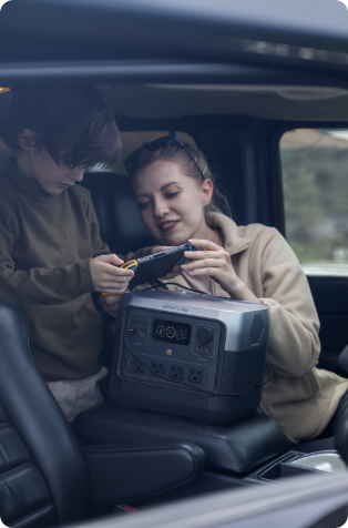 An image of an EcoFlow RIVER 2 Pro Portable Power Station being charged inside a car with a woman and her son using it to view a tablet.