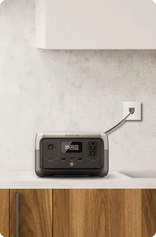 An image showing an EcoFlow RIVER 2 Portable Power Station sitting on a countertop, plugged into a wall outlet.